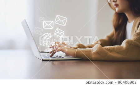 Woman using computer laptop and sending online message with email icon 96406902