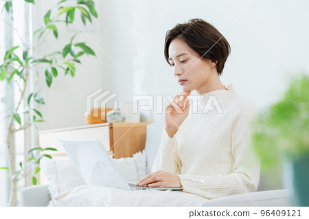 A woman heading to a computer in the living room A woman heading to a computer in the living room 96409121