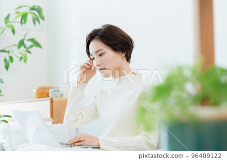 A woman heading to a computer in the living room A woman heading to a computer in the living room 96409122
