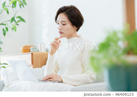 A woman heading to a computer in the living room A woman heading to a computer in the living room 96409123