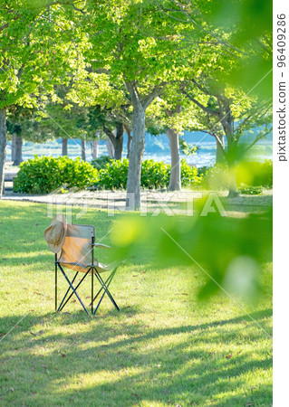 有椅子的一個綠色公園在樹蔭下 有椅子的一個綠色公園在樹蔭下 96409286