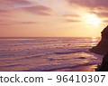 A flock of birds flying in the setting sun V-time flight of birds A flock of pelicans flying over the sea 96410307