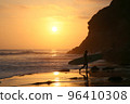 Longboarder walking on the sandy beach in the sunset Surfer walking on the beach with a surfboard 96410308