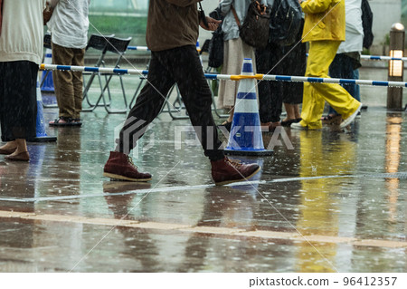 A person who walks quickly in a rainy town 96412357