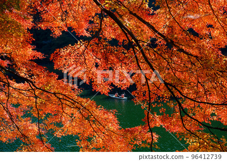 People fishing from boats under the beautifully colored foliage surrounding the lake People fishing from boats under the beautifully colored foliage surrounding the lake 96412739