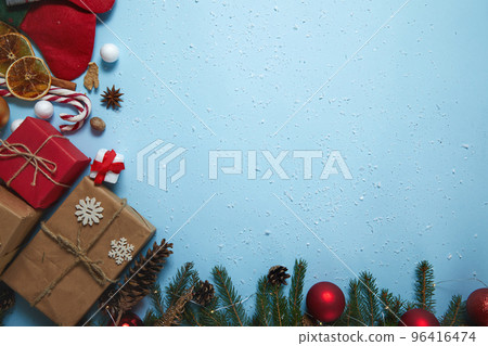 Beautiful Christmas composition on blue background. Christmas present boxes,socks, fir spruce branches,, conifer cones, caramel stick, gift. New Year. Top view, copy space. 96416474