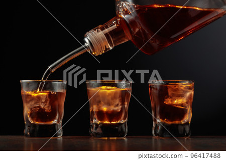Whiskey in glasses with ice. 96417488