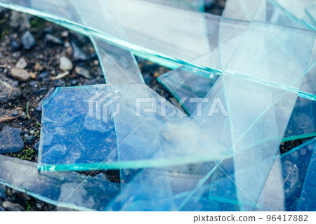 a small pile of broken glass lying on the asphalt 96417882