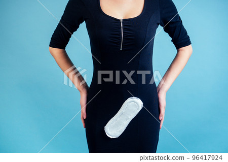 white sanitary napkin on a black dress of a woman on a blue background white sanitary napkin on a black dress of a woman on a blue background 96417924