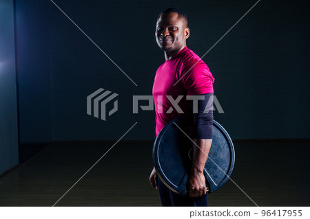 young african american man sportsman squatting sportsman exercising dumbbell T-shirt sports uniforms sport wear black background studio gym young african american man sportsman squatting sportsman exercising dumbbell T-shirt sports uniforms sport wear black background studio gym 96417955