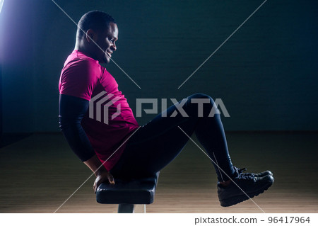 Black african american athletic man running on treadmills idoing exercises on muscle groups push up from the bench gym on black background Black african american athletic man running on treadmills idoing exercises on muscle groups push up from the bench gym on black background 96417964