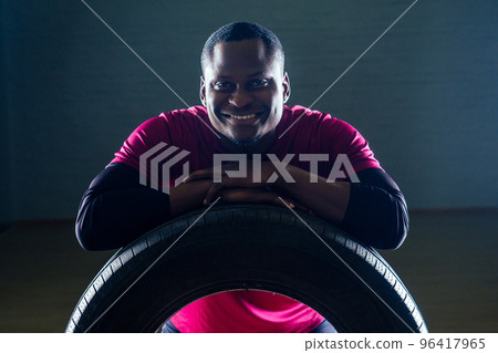 muscular shirtless young african american man in sportswear tire exercising with tyre in gym on a black background in the studio workshop muscular shirtless young african american man in sportswear tire exercising with tyre in gym on a black background in the studio workshop 96417965