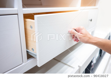 Male hand opening drawer on white cabinet Male hand opening drawer on white cabinet 96418027
