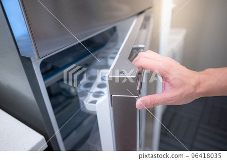 Male hand opening fridge or refrigerator door in kitchen Male hand opening fridge or refrigerator door in kitchen 96418035