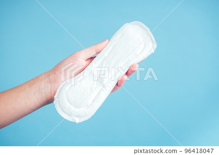 white sanitary napkin iin the girl's hand on a blue background white sanitary napkin iin the girl's hand on a blue background 96418047