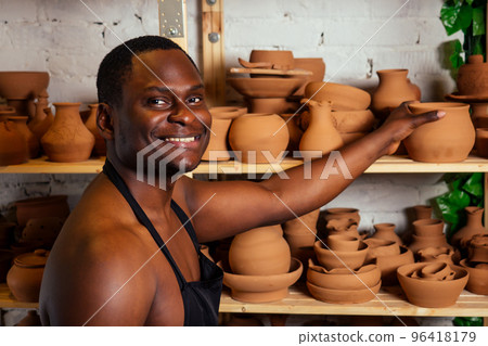 happy dark-skinned african american businessman potter man molding In workshop. sculptor pottering clay pot in a studio workplace. creativity and inspiration of the artist happy dark-skinned african american businessman potter man molding In workshop. sculptor pottering clay pot in a studio workplace. creativity and inspiration of the artist 96418179