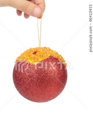 Hand holds a red christmas ball.  96418455