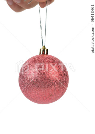 Hand holds a red christmas ball. 96418461
