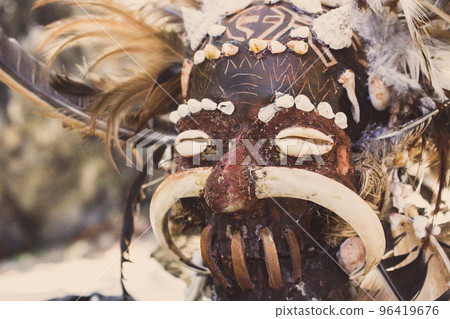 Scary wooden mask of asian totem. Head of ritual sculpture. Carnival decoration. Trible symbol. Ancient religious mask. Culture and religion concept. Scary wooden mask of asian totem. Head of ritual sculpture. Carnival decoration. Trible symbol. Ancient religious mask. Culture and religion concept. 96419676