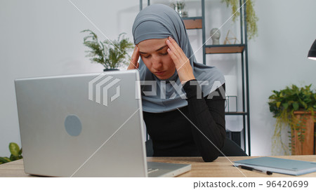 Tired muslim business woman use laptop suffering from headache problem tension, migraine, stress 96420699
