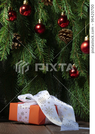 Christmas gift on the background of the Christmas tree close-up Christmas gift on the background of the Christmas tree close-up 96420700