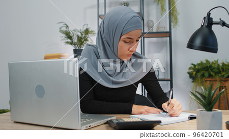 Muslim business woman accountant working with financial document bills, calculate taxes in office 96420701