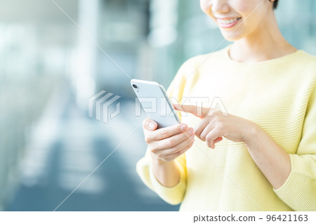 Young woman operating a smartphone (parts model) Young woman operating a smartphone (parts model) 96421163