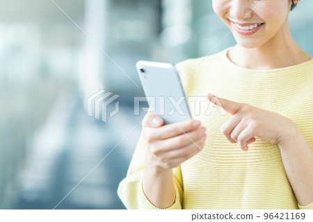 Young woman operating a smartphone (parts model) Young woman operating a smartphone (parts model) 96421169