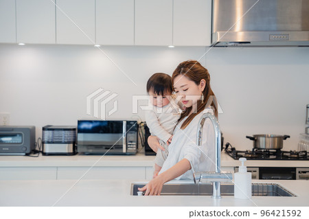 媽媽抱著寶寶做家務 96421592