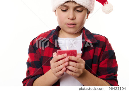 Close-up portrait of a handsome preteen Caucasian boy with a lit candle, isolated on white background. Adorable child making wish. Merry Christmas, Happy New Year and winter holidays. Copy ad space Close-up portrait of a handsome preteen Caucasian boy with a lit candle, isolated on white background. Adorable child making wish. Merry Christmas, Happy New Year and winter holidays. Copy ad space 96423104