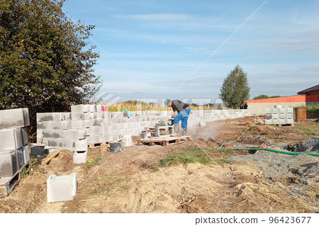 Construction of a fence on a private territory, a worker while performing work. 96423677