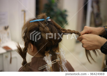 Male hairdresser tying woman's hair Male hairdresser tying woman's hair 96424969