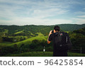 Young man traveller with backpack using camera take a photo of nature 96425854
