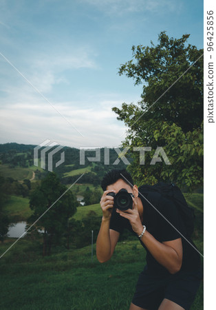Front view point of young man traveller using his camera for take a photo 96425856