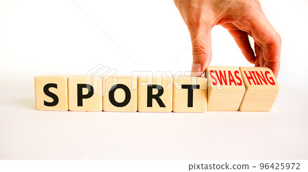 Sport or sportswashing symbol. Concept words Sport and Sportswashing on wooden cubes. Businessman hand. Beautiful white table white background. Business sport sportswashing concept. Copy space. 96425972
