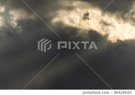 Beams of light of sun's rays through clouds in morning. 96426683