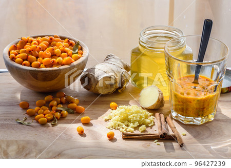 Squeezed seabberry in glass with other ingredients for healthy tea Squeezed seabberry in glass with other ingredients for healthy tea 96427239