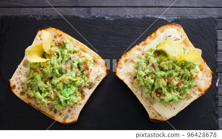 toasted slices of square bread with warm cheese and homemade guacamole on plate for healthy breakfast toasted slices of square bread with warm cheese and homemade guacamole on plate for healthy breakfast 96428678