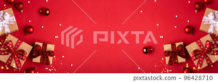 Christmas gift boxes with red balls and christmas lights on red background. 96428710