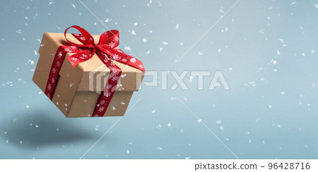 Flying Christmas gift box and snow on blue background. 96428716