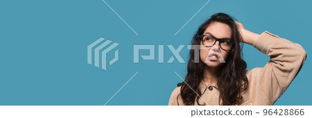 Interesting Offer. Doubtful young woman scratching head and looking aside, wide banner Interesting Offer. Doubtful young woman scratching head and looking aside, wide banner 96428866