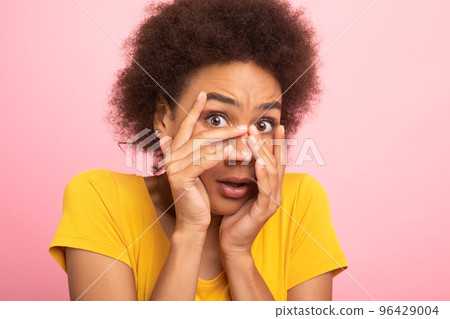 Scared millennial african american curly woman student in yellow t-shirt covering her face with hands and afraid Scared millennial african american curly woman student in yellow t-shirt covering her face with hands and afraid 96429004