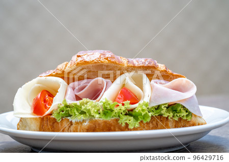 Croissant filled with ham, cheese and vegetables Croissant filled with ham, cheese and vegetables 96429716