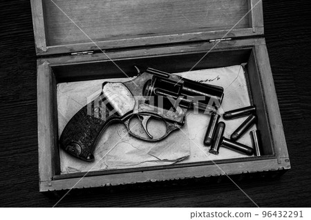 Antique vintage revolver gun with ammunition in wooden box for letters. Black and white photo. Antique vintage revolver gun with ammunition in wooden box for letters. Black and white photo. 96432291