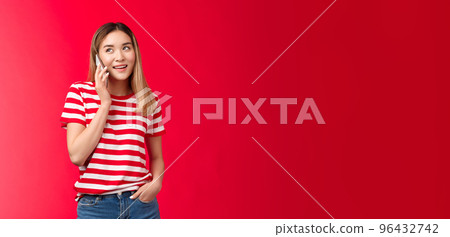 Girl calling friend arranging meeting. Cute modern asian woman hold smartphone near ear look away speaking, smiling delighted have pleasant carefree conversation standing relaxed talking phone 96432742