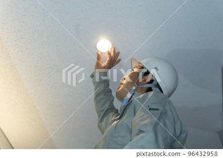 A worker who replaces a bulb 96432958