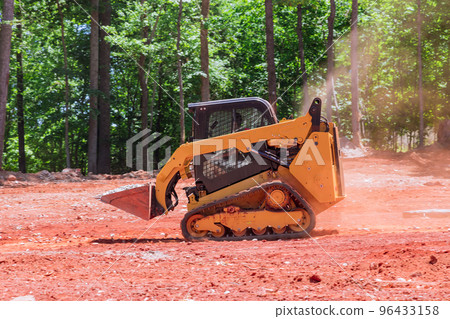 A bobcat with help of mini loader transports crushed stone to construction site A bobcat with help of mini loader transports crushed stone to construction site 96433158