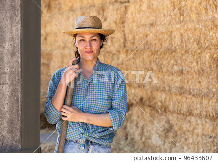 Asian woman farmer resting on hayloft 96433602