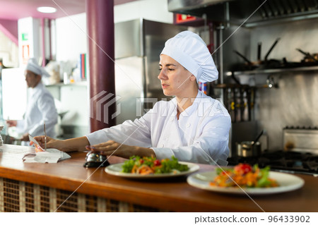 Chef checking orders and giving out meal Chef checking orders and giving out meal 96433902