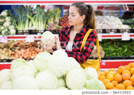Positive customer chooses cabbages at grocery store Positive customer chooses cabbages at grocery store 96433903